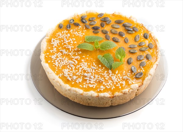 Traditional american sweet pumpkin pie decorated with mint, sesame and pumpkin seeds isolated