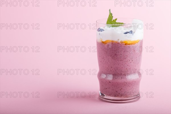 Smoothie with honeysuckle, linen and chia in a glass on pink pastel background. side view, close