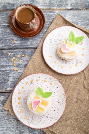 Decorated cake with milk and coconut cream with cup of coffee on a gray wooden background and linen