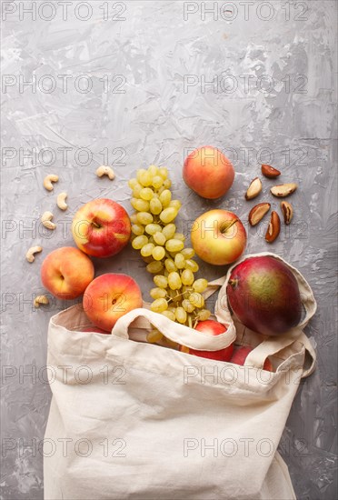 Fruits in reusable cotton textile white bag. Zero waste shopping, storage and recycling concept,