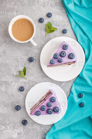 Homemade cake with souffle cream and blueberry jam with cup of coffee and fresh blueberries on a