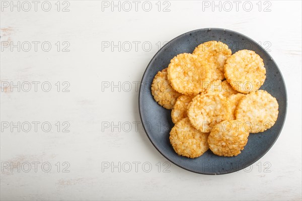Traditional japanese rice chips cookies with honey and soy sauce on a blue ceramic plate on a white