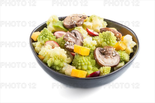 Vegetarian salad from romanesco cabbage, champignons, cranberry, avocado and pumpkin in black bowl