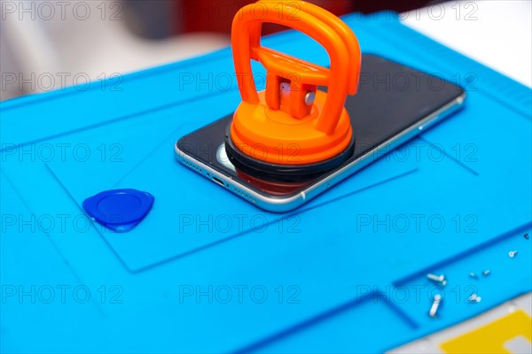 Close-up photo of a suction cup pressing the screen of a mobile to attach it in the desk of a