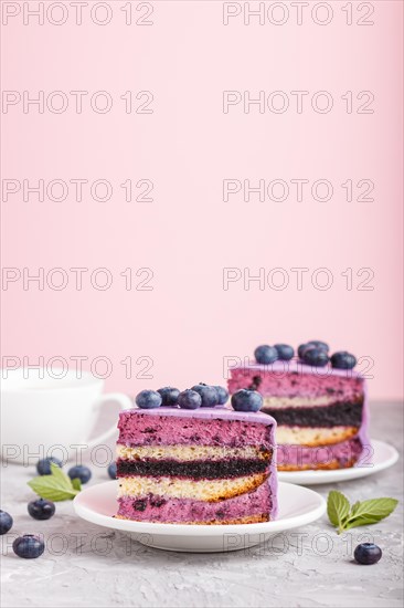 Homemade cake with souffle cream and blueberry jam with cup of coffee and fresh blueberries on gray