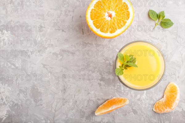 Glass of orange juice on a gray concrete background. Morninig, spring, healthy drink concept. Top