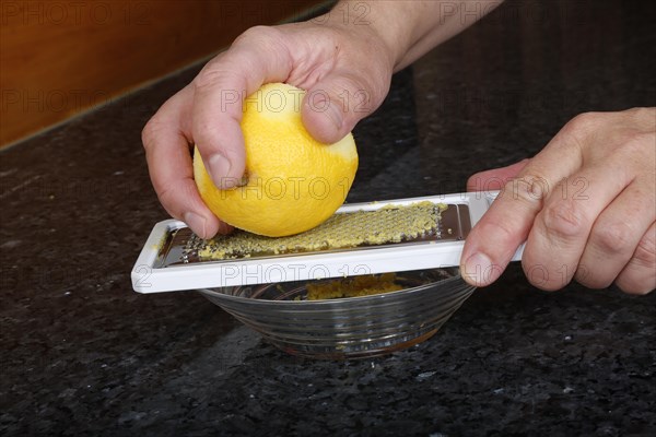 Preparation lemon sauce for fillet of Dreisam salmon with wild rice, grating lemon peel, kitchen