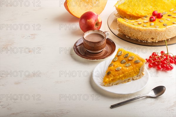 Traditional american sweet pumpkin pie decorated with hawthorn red berries and pumpkin seeds with