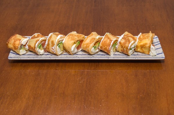 A plate of sushi rolls topped with cream sauce and slices of green lettuce, Majorca, Balearic