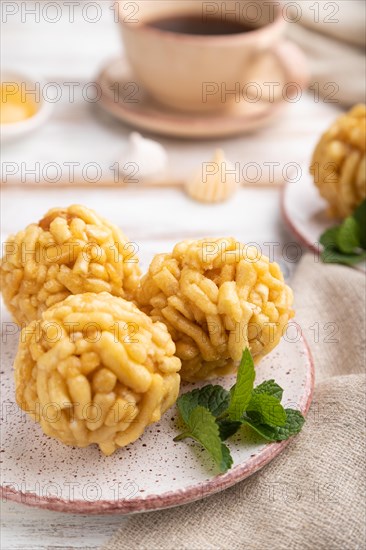 Traditional Tatar candy chak-chak made of dough and honey with cup of coffee on a white wooden