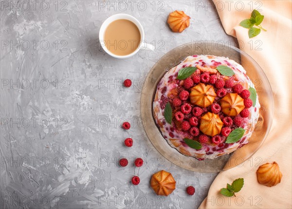Homemade jelly cake with milk, cookies and raspberry on a gray concrete background with cup of