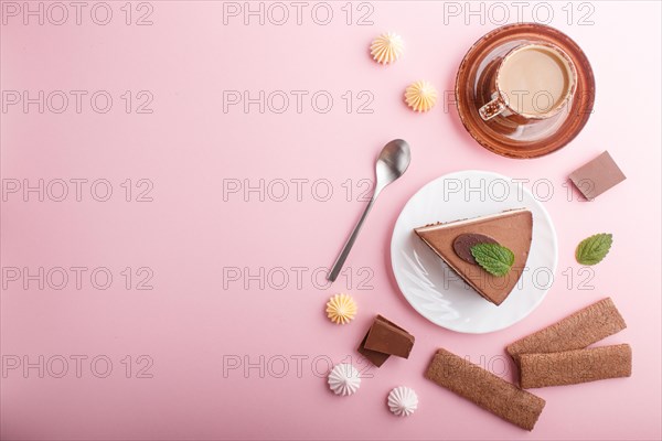 Cake with souffle milk chocolate cream with cup of coffee, meringues on a pink pastel background.