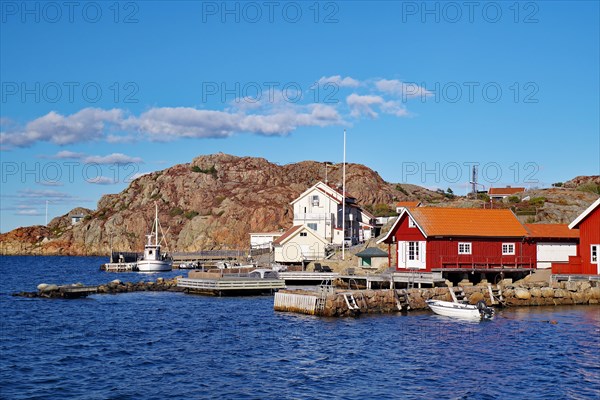 Colourful fishermen's huts nestled against high rocks, small fishing boat, autumn, Vaestra