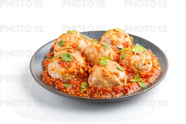 Pork meatballs with tomato sauce, oregano leaves, spices and herbs on blue ceramic plate isolated