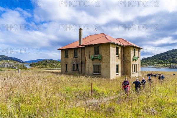 Hikers in front of the museum at a historic Yaghan aboriginal settlement, Wulaia Bay, Navarino