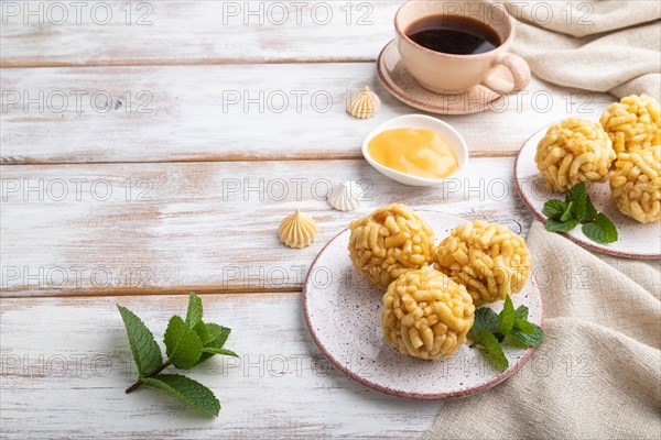 Traditional Tatar candy chak-chak made of dough and honey with cup of coffee on a white wooden