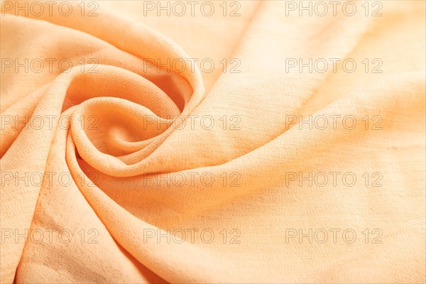 Fragment of orange linen tissue. Side view, natural textile background and texture. wave concept,