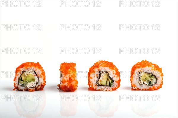 Four Japanese maki sushi rolls in a row with flying fish roe, avocado, and cucumber isolated on