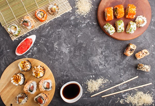 Different kinds of Japanese maki sushi rolls with salmon, sesame, cheese, roe and chopsticks, soy
