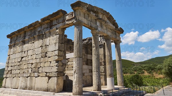 Ancient columned building in front of a blue sky with decorative clouds, Mausoleum, Heroon,