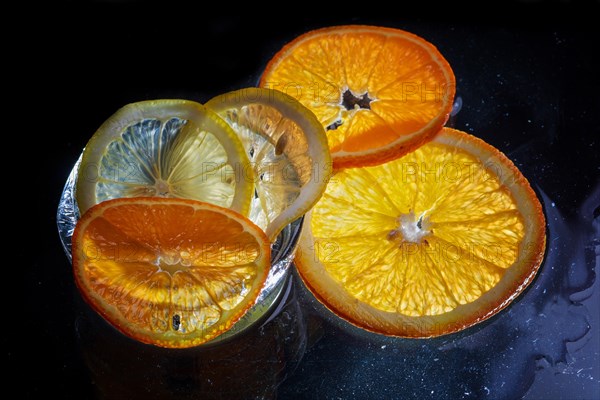 Transparent slices of fresh oranges and lemons on the glass with ice