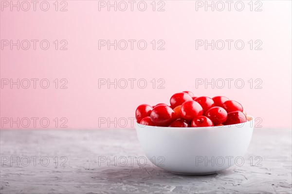 Fresh red sweet cherry in white bowl on gray and pink background. side view, close up, selective