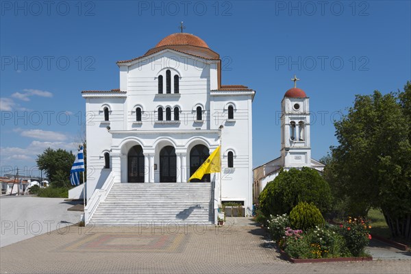An imposing whitewashed church with a red roof and bell tower on a sunny day, Greek Orthodox Church