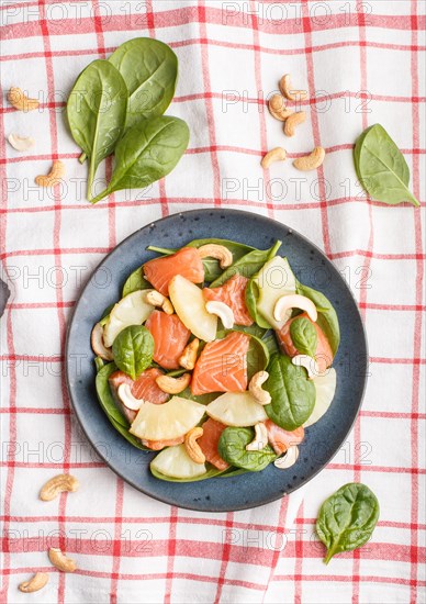 Fresh salmon with pineapple, spinach and cashew on a gray concrete background. Top view, flat lay,
