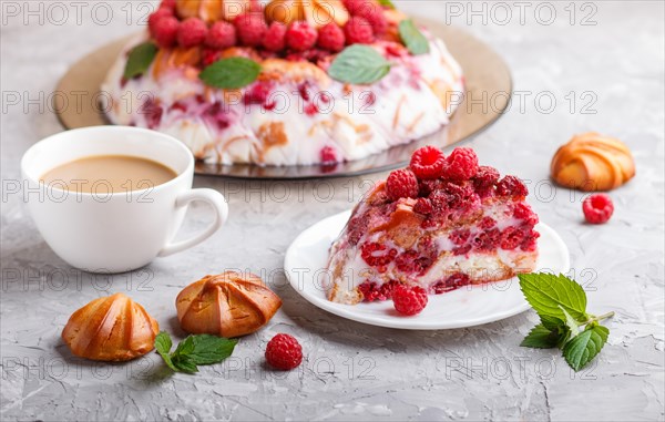 Homemade jelly cake with milk, cookies and raspberry on a gray concrete background with cup of