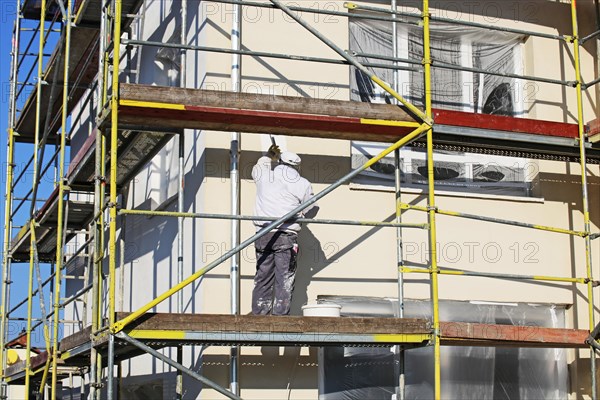 Painter painting the facade of a new residential building (Mutterstadt development area,