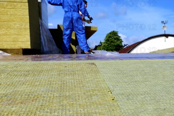 Employees of Uwe Adrian Bauspenglerei GmbH from Worms insulate the roof of a multi-purpose hall in