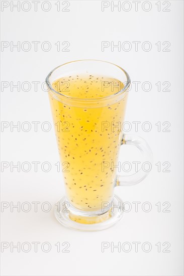 Glass of tangerine orange colored drink with basil seeds isolated on white background. Morninig,