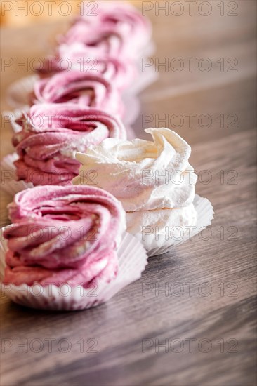 Pink and white homemade marshmallows on a gray wooden background. selective focus