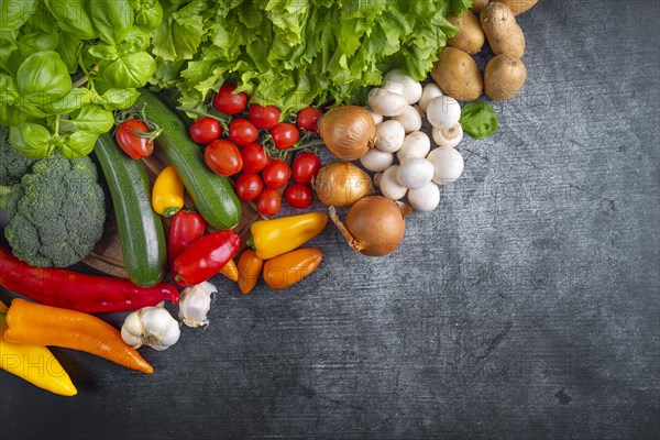 Fresh lettuce, courgettes, broccoli, tomatoes, peppers, mushrooms, onions and potatoes arranged on