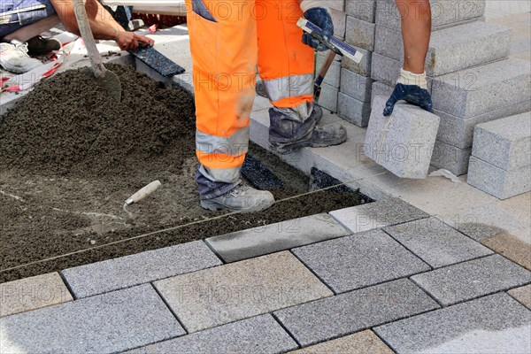Worker lays paving stones