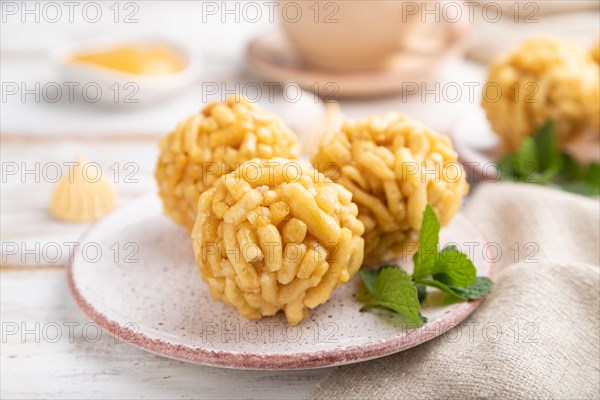 Traditional Tatar candy chak-chak made of dough and honey with cup of coffee on a white wooden
