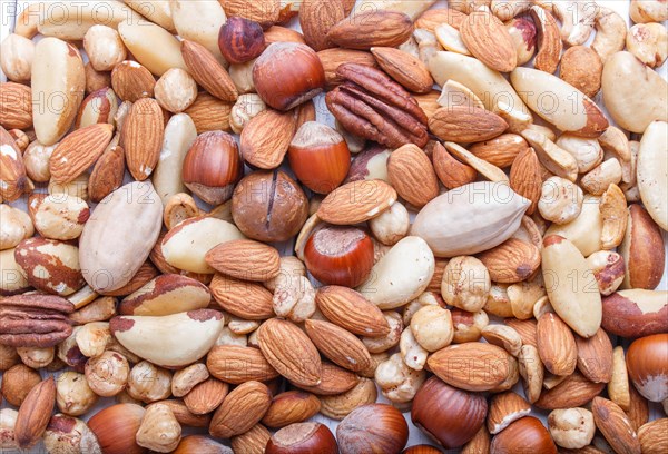 Background and texture made from different kinds of nuts. hazelnut, brazil nut, almond, pumpkin