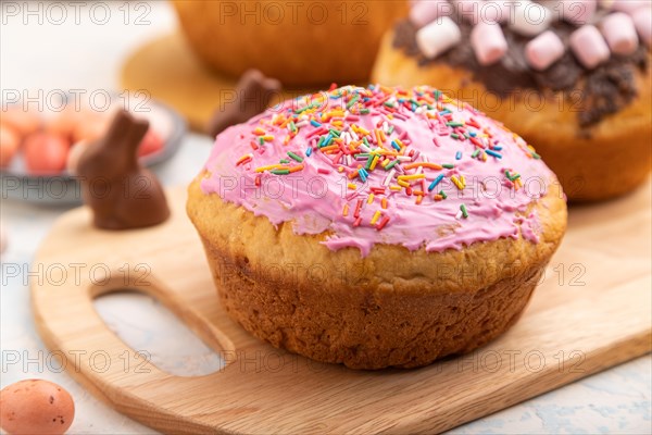 Homemade glazed and decorated easter pies with chocolate eggs and rabbits on a white concrete