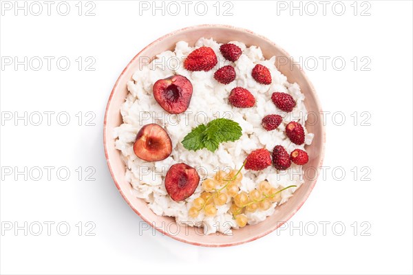 Rice flakes porridge with milk and strawberry in ceramic bowl isolated on white background. Top