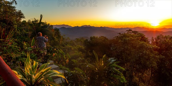 A tourist photographs the sunrise at Finca Don Gabriel, Pluma Hidalgo, Pochutla, Oxaca state,