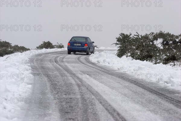 Blue rental car in the snow of the highest mountain Roque de los Muchachos altitude 2400 m, La