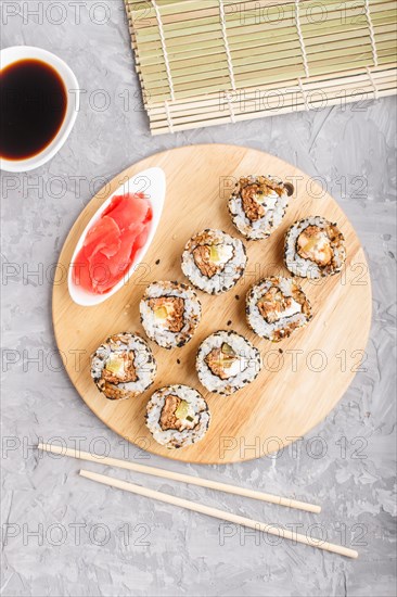 Japanese maki sushi rolls with salmon, sesame, cucumber chopsticks, soy sauce and marinated ginger
