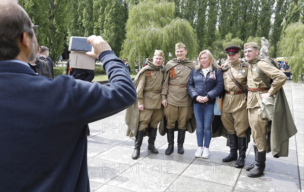 Men in Russian uniforms take a group photo at the Soviet memorial in Treptow Park to mark the 74th