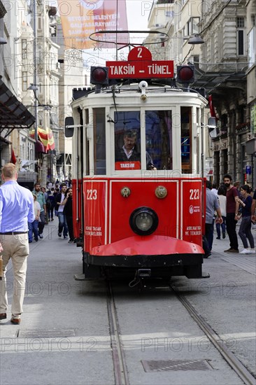 Historic tram Nostaljik Tramvay travelling through Istiklal Caddesi shopping street, Beyoglu,