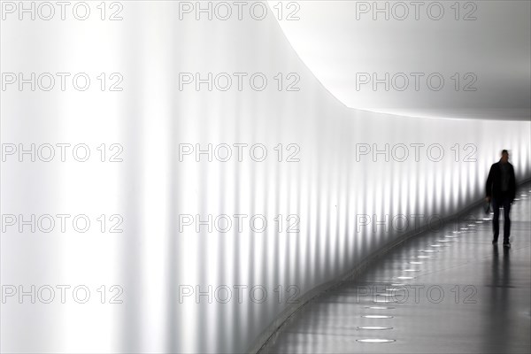 Members of the German Bundestag walk through a tunnel. The tunnel connects the Reichstag and the
