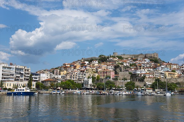 View of a Mediterranean coastal town with a fortress on a hill and boats at the pier, Old Town,
