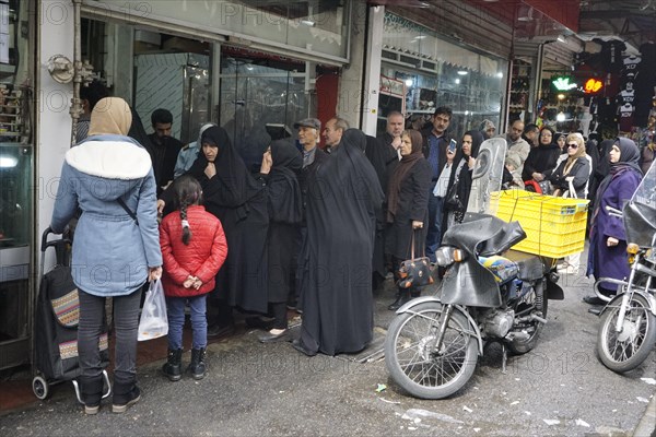 Shopping for the upcoming Persian New Year, queue in front of a butcher shop in a bazaar in Tehran,