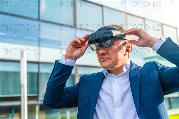 Close-up with copy space of a serious businessman using a virtual reality headset outside a modern
