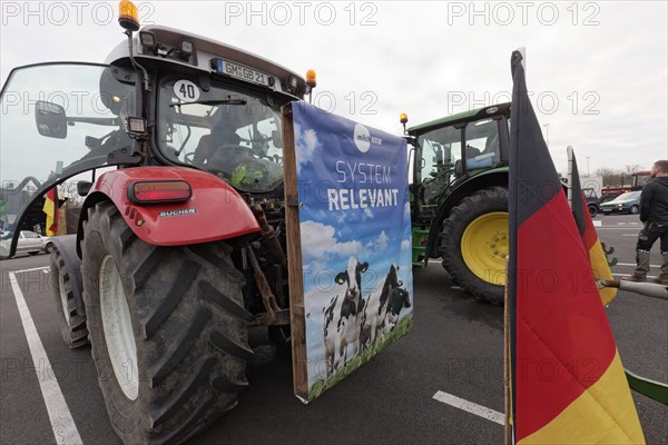 Poster with dairy cows and writing Systemrelevant on a tractor, farmer protests, demonstration