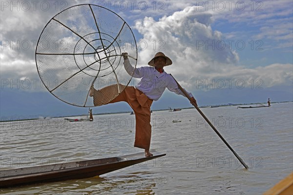 Intha fisherman, local man fishing with traditional conical fishing net, Inle Lake, Burma, Myanmar,